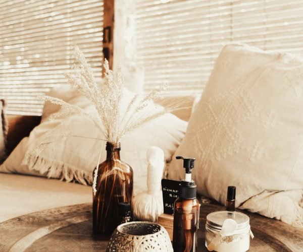 una cama con una fuente encima con botes de perfumes y un jarrón