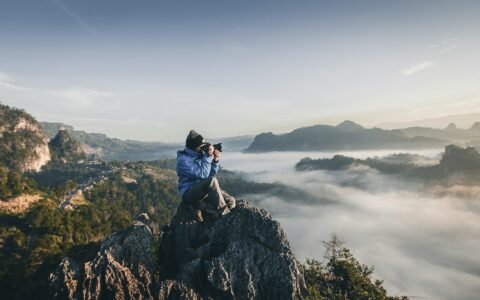 chico en montaña haciendo una foto